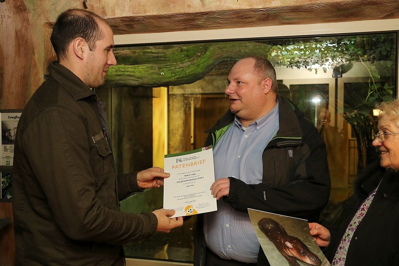 Zoodirektor Dennis Müller und Fördervereinsgeschäftsführerin Irmela Dorn übergeben die Patenschaftsurkunde für Inola an Hendrik Lange