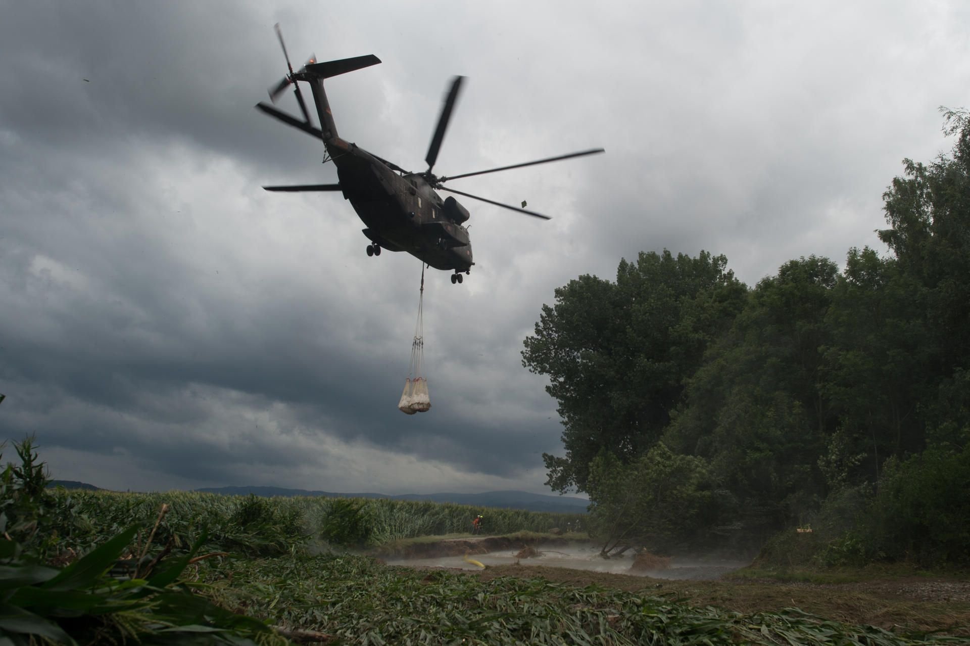 Ein CH-53 Transporthubschraubers der Bundeswehr setzt in Silstedt mit Sand gefüllte Kunststoffsäcke in die Holtemme ab.