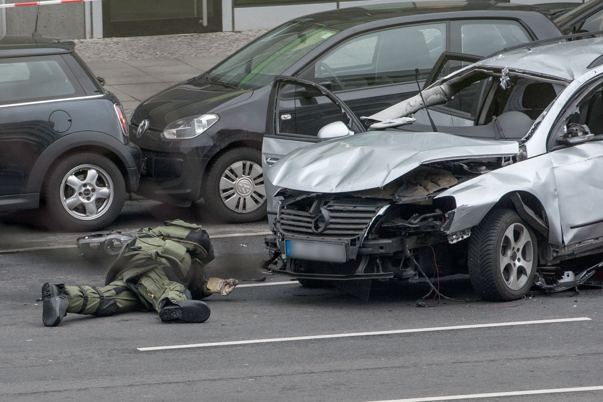 Ein Bombenexperte untersucht den explodierten Passaat nach weiteren Sprengsätzen.