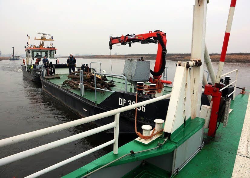 Ein vor Mauken liegendes Arbeitsschiff der Wasser- und Schifffahrtsdirektion hilft beim Drehen der Fähre. Auf Hölzern „rollt“ der Stahlkoloss nach oben auf den Fährberg.