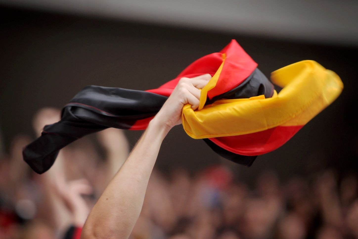 Ein Fußballfan schwenkt die deutsche Fahne.