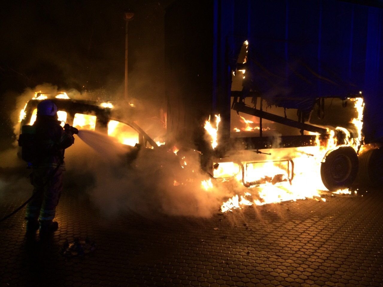 Ein Feuerwehrmann löscht in der Nacht zu Freitag auf der B100 bei Brehna ein brennendes Auto.