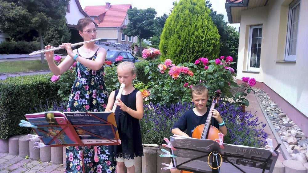 Andrea Wulff-Woesten und ihre Kinder Sophia und Christoph geben ein kleines Konzert für die Nachbarschaft.