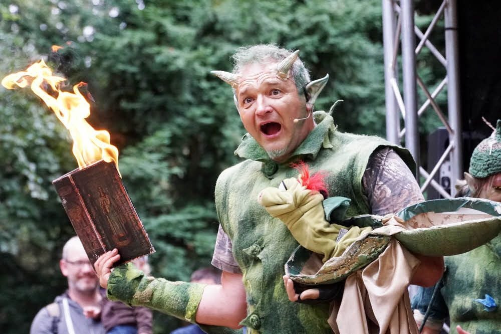 Der Drache des Elfen Herrn Blühterig hat im Theaterstück ein Buch angezündet.