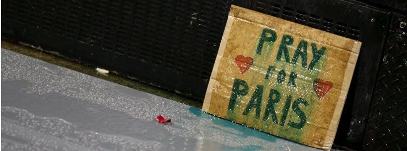 Ein Plakat mit der Aufschrift "Pray for Paris" (Beten für Paris) lehnt an einer Mauer zum Gedenken an die Opfer der Anschläge von Paris.