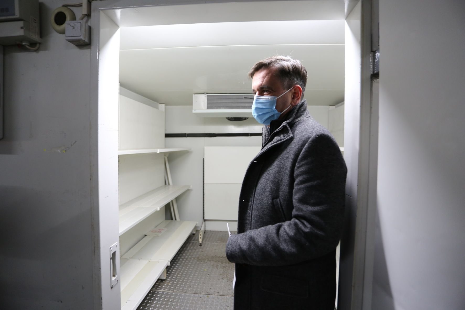 Landrat Thomas Balcerowski (CDU) steht vor einer Kühlkammer des Impfzentrums in Quedlinburg.