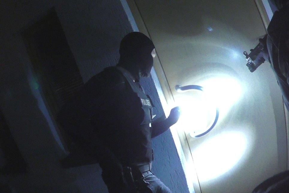 Polizisten beim Zugriff während einer der vier Hausdurchsuchungen.