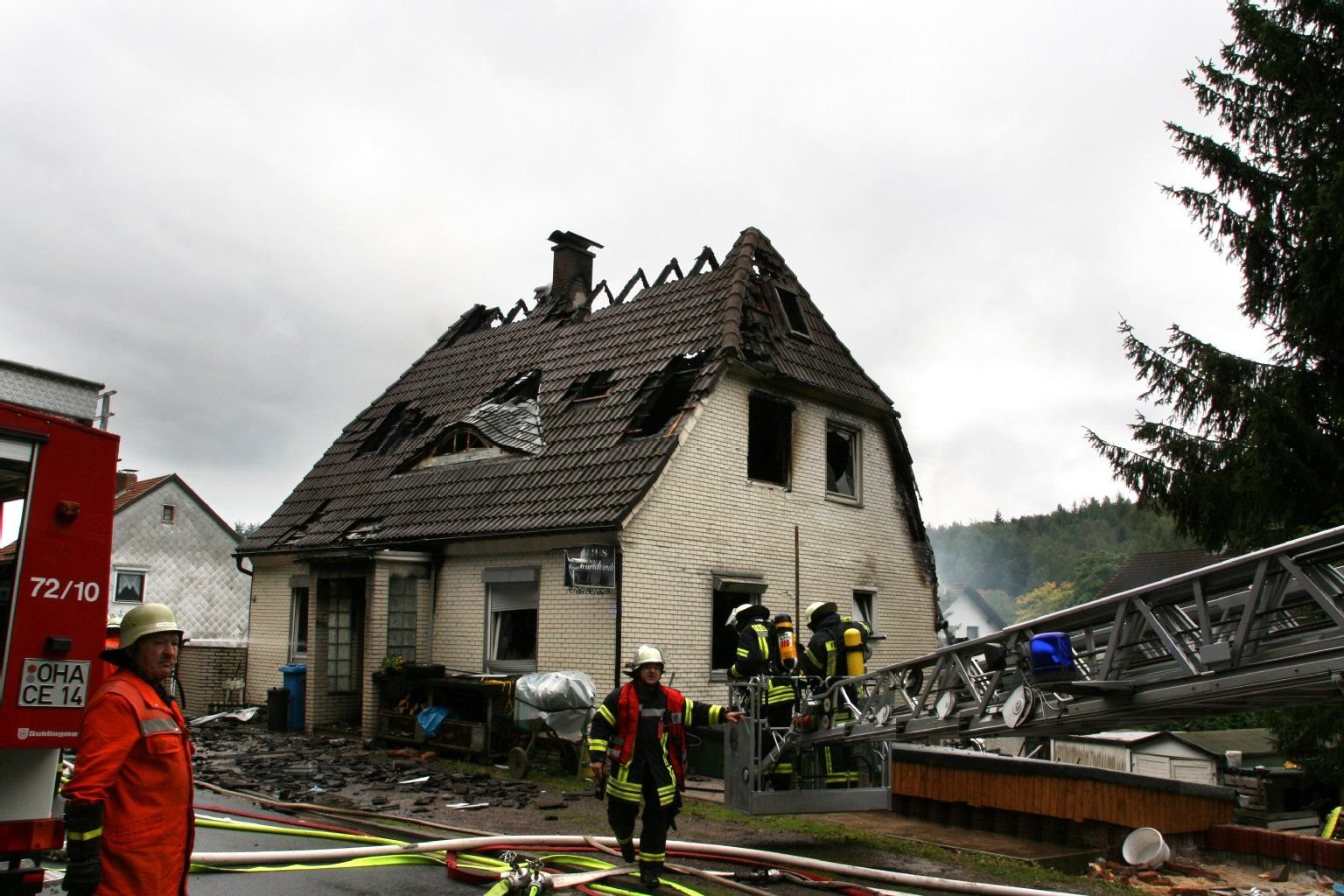 Feuerwehrmänner arbeiten in Wieda (Kreis Osterrode) an einem angebrannten Haus. Bei einer Gasexplosion mit anschließendem Brand kam ein dreijähriges Mädchen ums Leben.