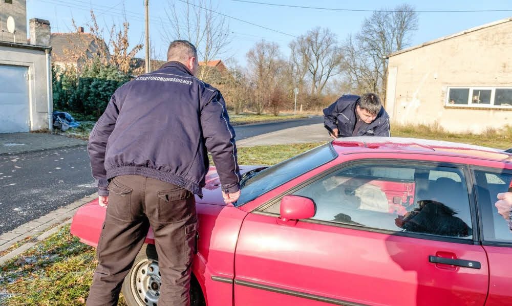 Kevin Weise (l.) und Marco Pfeifer am Schrottauto in Seegrehna.
