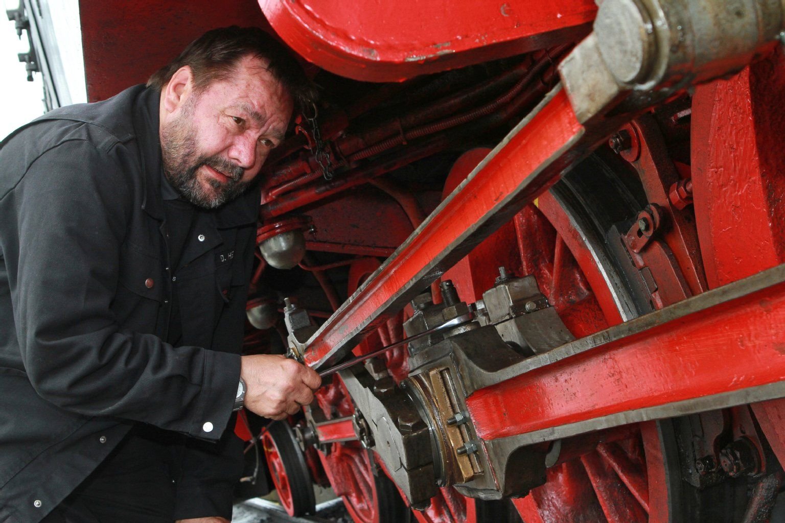 Lokführer Dieter Hellmund prüft am 26.04.2013 das Fahrgestell einer Dampflok in Wernigerode