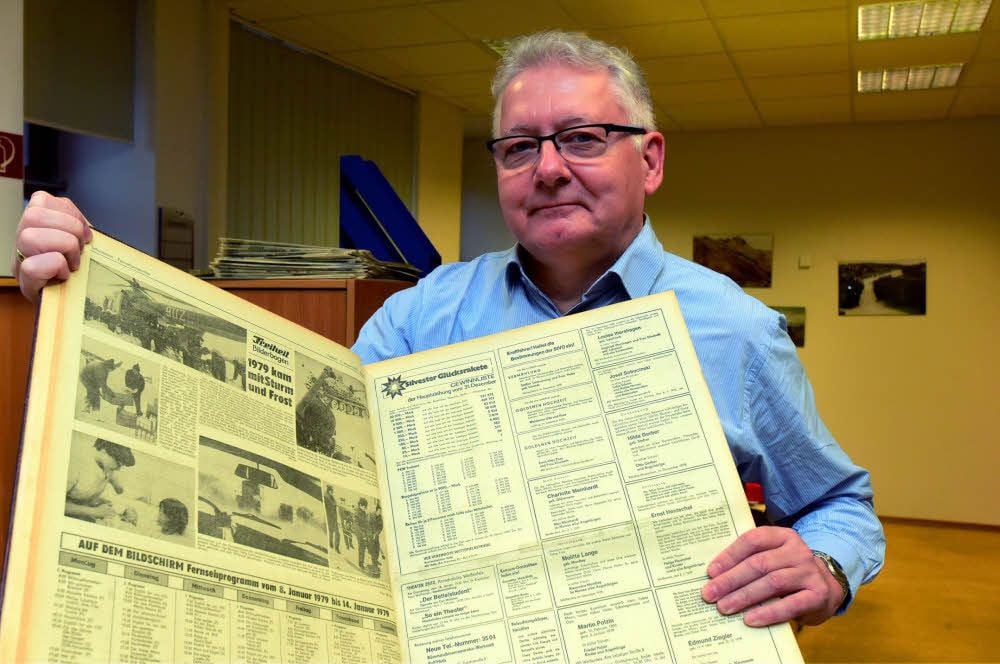Tobias Liebert hält einen Band der Tageszeitung „Freiheit“ mit einem Bildkomplex zu den Katastrophentagen von Anfang 1979 in die Kamera.