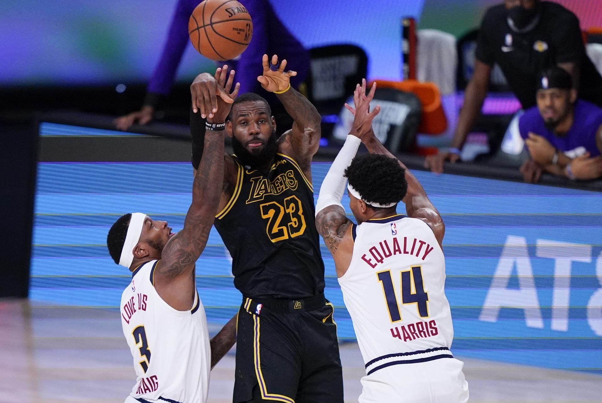 LeBron James (M) von den Los Angeles Lakers gegen Torrey Craig (l) und Gary Harris (r) von den Denver Nuggets.