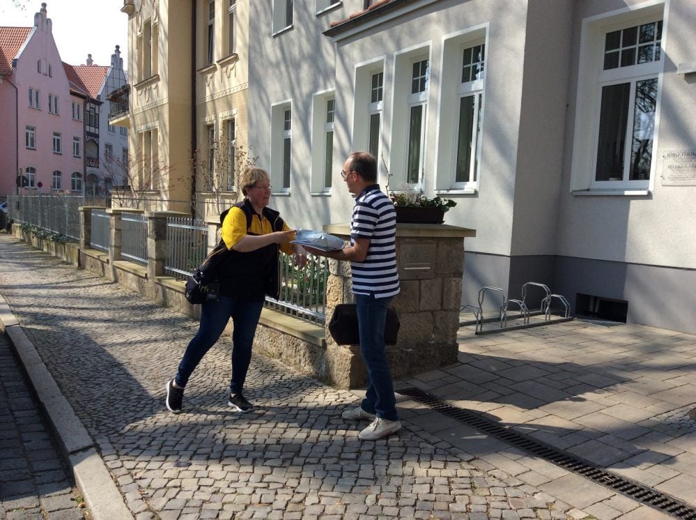 Zwei, die trotz Corona-Krise alles am Laufen halten: Auf dem Weg zu seinen Palliativ-Patienten nimmt Jörg Thomas noch schnell die Post entgegen.