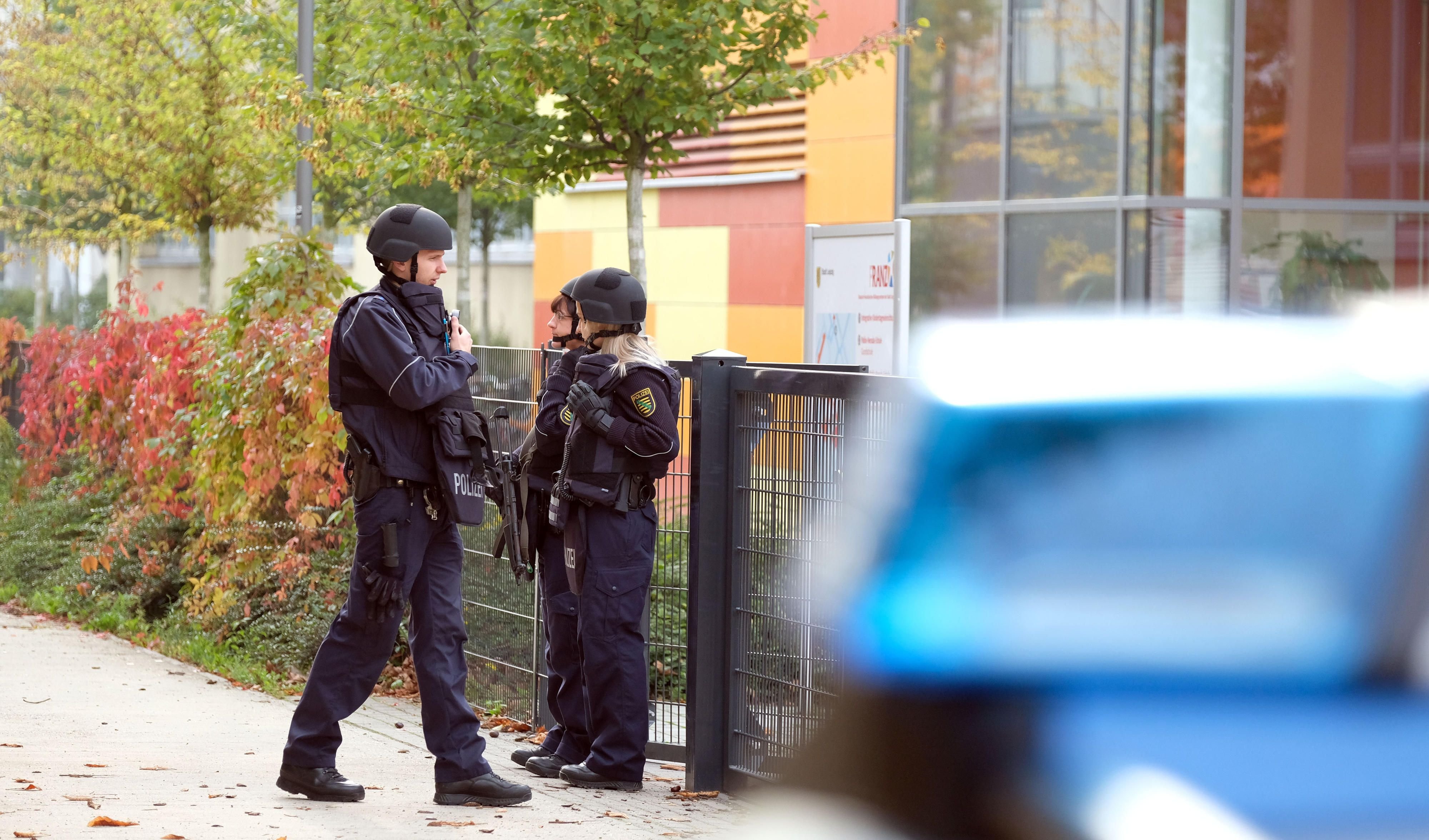Ein Unbekannter hatte am Montag mehreren Schulen in Leipzig und Magdeburg mit einem Amok-Lauf gedroht. Hier stehen Polizisten vor dem Reclam-Gymnasium in Leipzig.