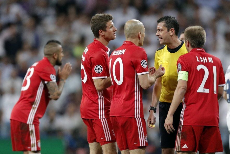 Die Spieler von Bayern München diskutieren mit Schiedsrichter Viktor Kassai (r.).