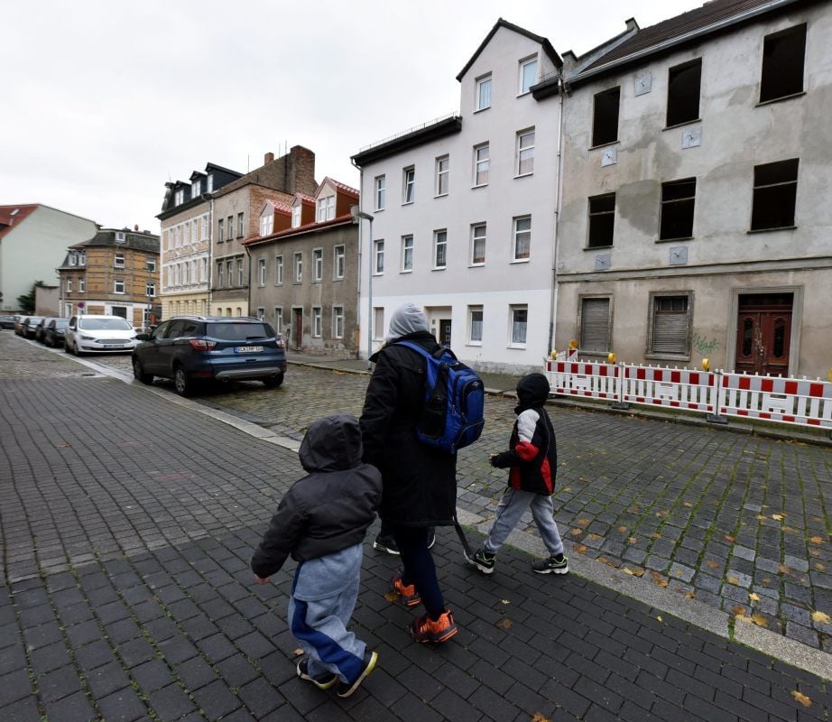 Eine Anwohnerin läuft mit ihren Kindern am Tatort vorbei.