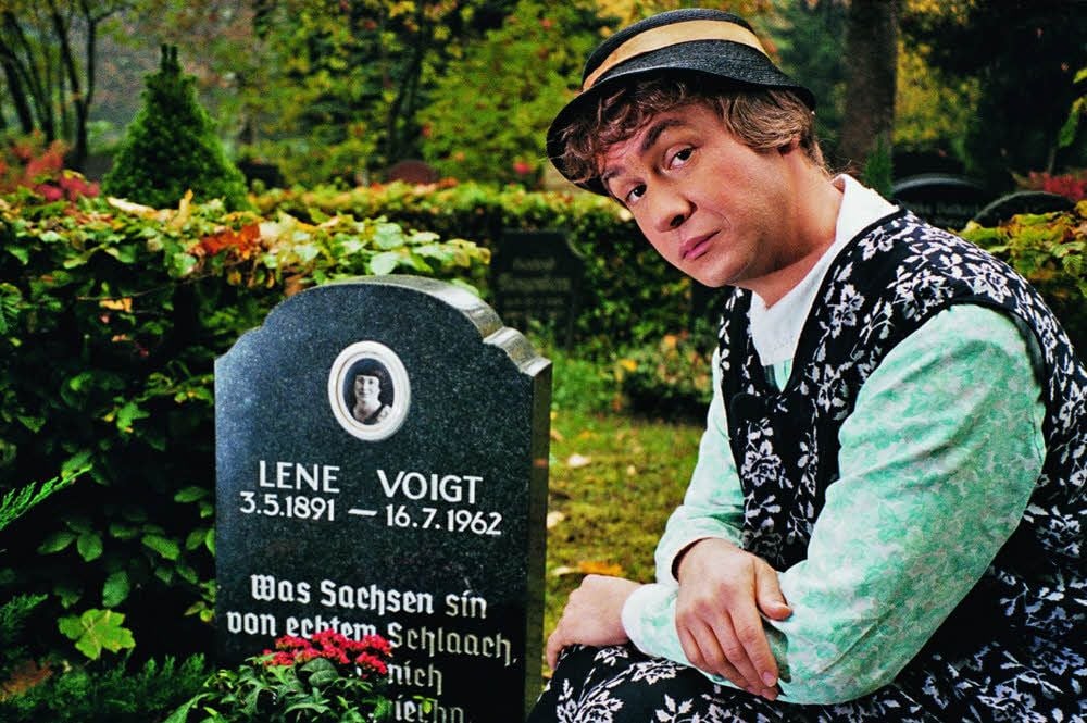 Der Schauspieler, die Kunstfigur und die Erinnerung deren Schöpferin: Tom Pauls als Rentnerin Ilse Bähnert am Grab von Lene Voigt in Leipzig