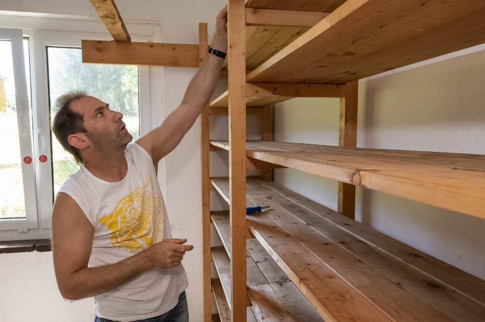 Rainer Heinrich baut Regale aus, damit die Arbeiten im Raum beginnen können.