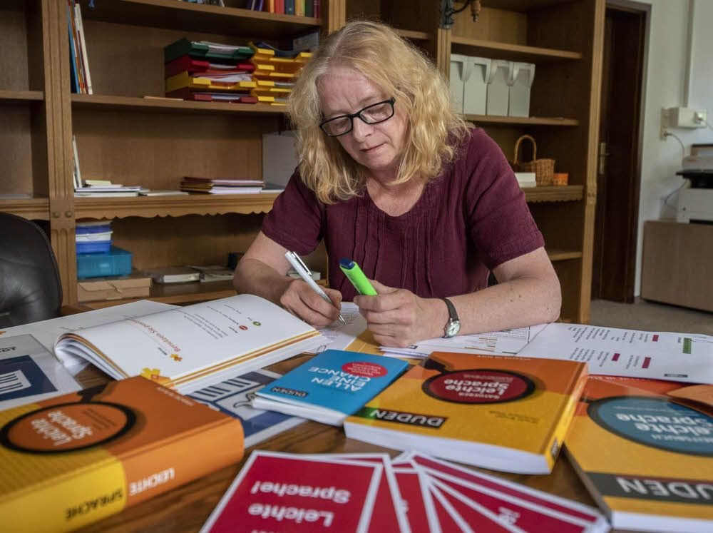 Silvia John markiert in einem Text schwierige Wörter und Sätze. Dann überlegt sie, wie man dieselbe Aussage einfacher formulieren könnte.