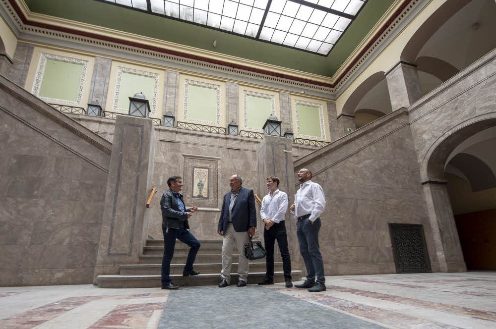 Thomas Balcerowski, Rainer Kleinschmidt, Leon Kleinschmidt und Michael Gruenewald im Lichthof des Gebäudes im Gespräch.