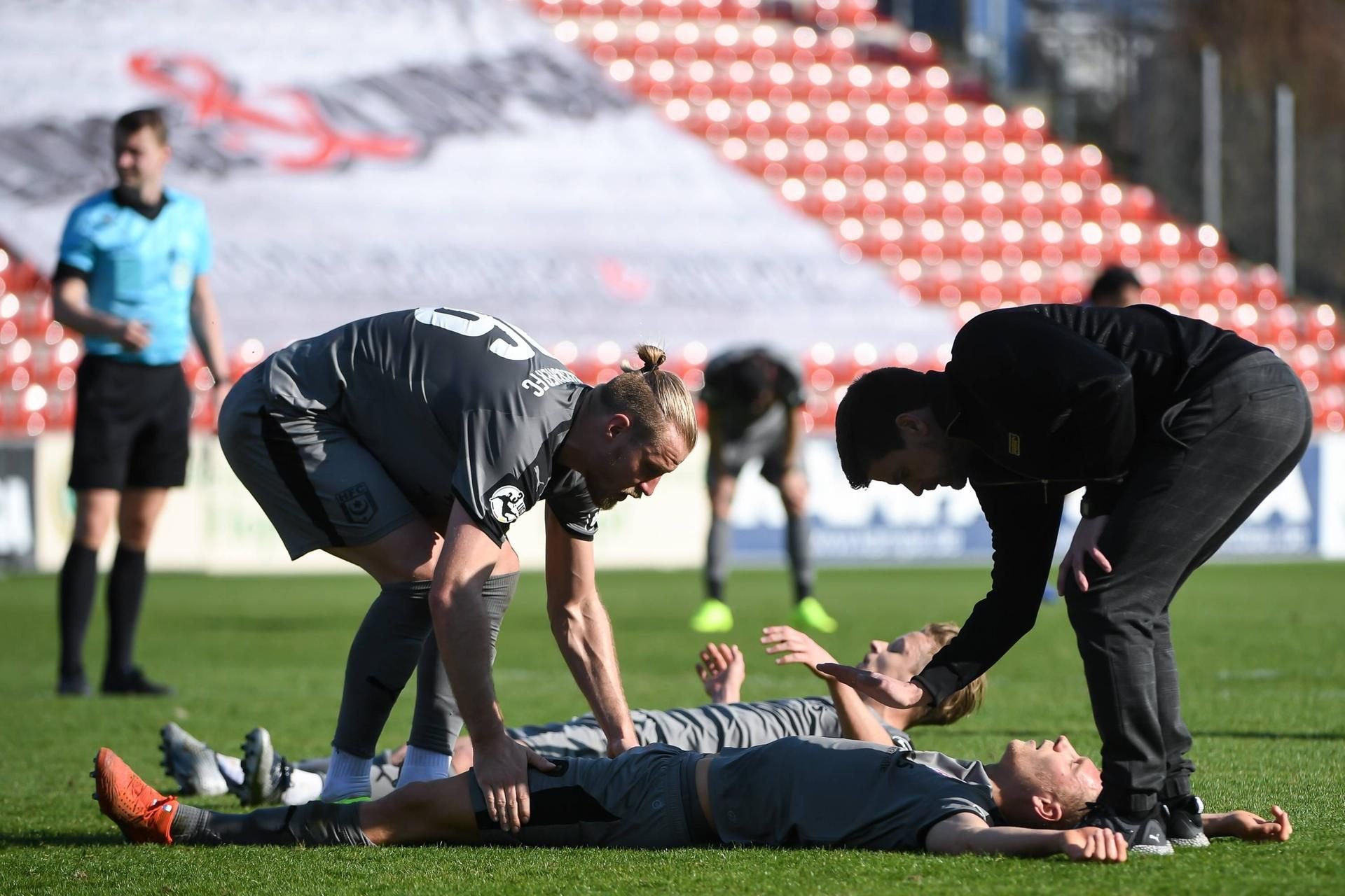 Bentley Baxter Bahn und Tobias Schilk (v.) bleiben nach Spielende erschöpft liegen. Sebastian Mai und Trainer Torsten Ziegner helfen.