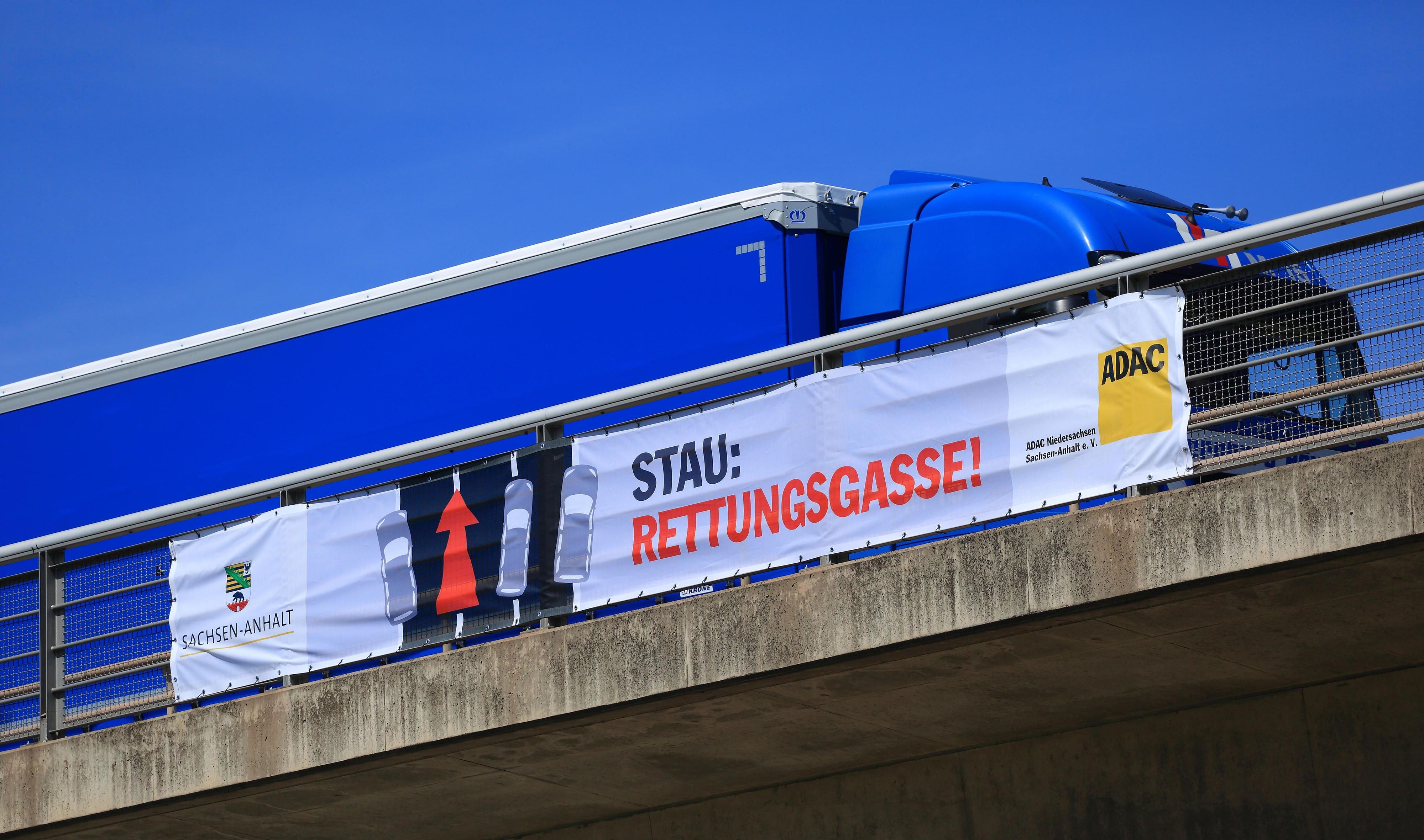 Ein Banner mit der Aufschrift "Stau: Rettungsgasse!" hängt am an einer Brücke der Autobahn 2 in Hohenwarsleben.
