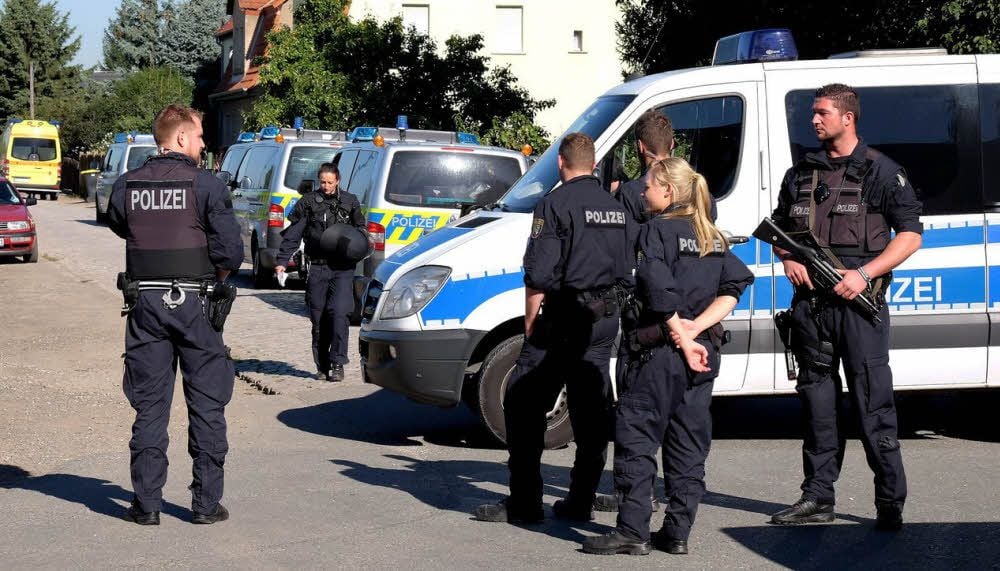 Schwer bewaffnete Polizisten sichern nach der Zwangsräumung die Alte Poststraße in Reuden.
