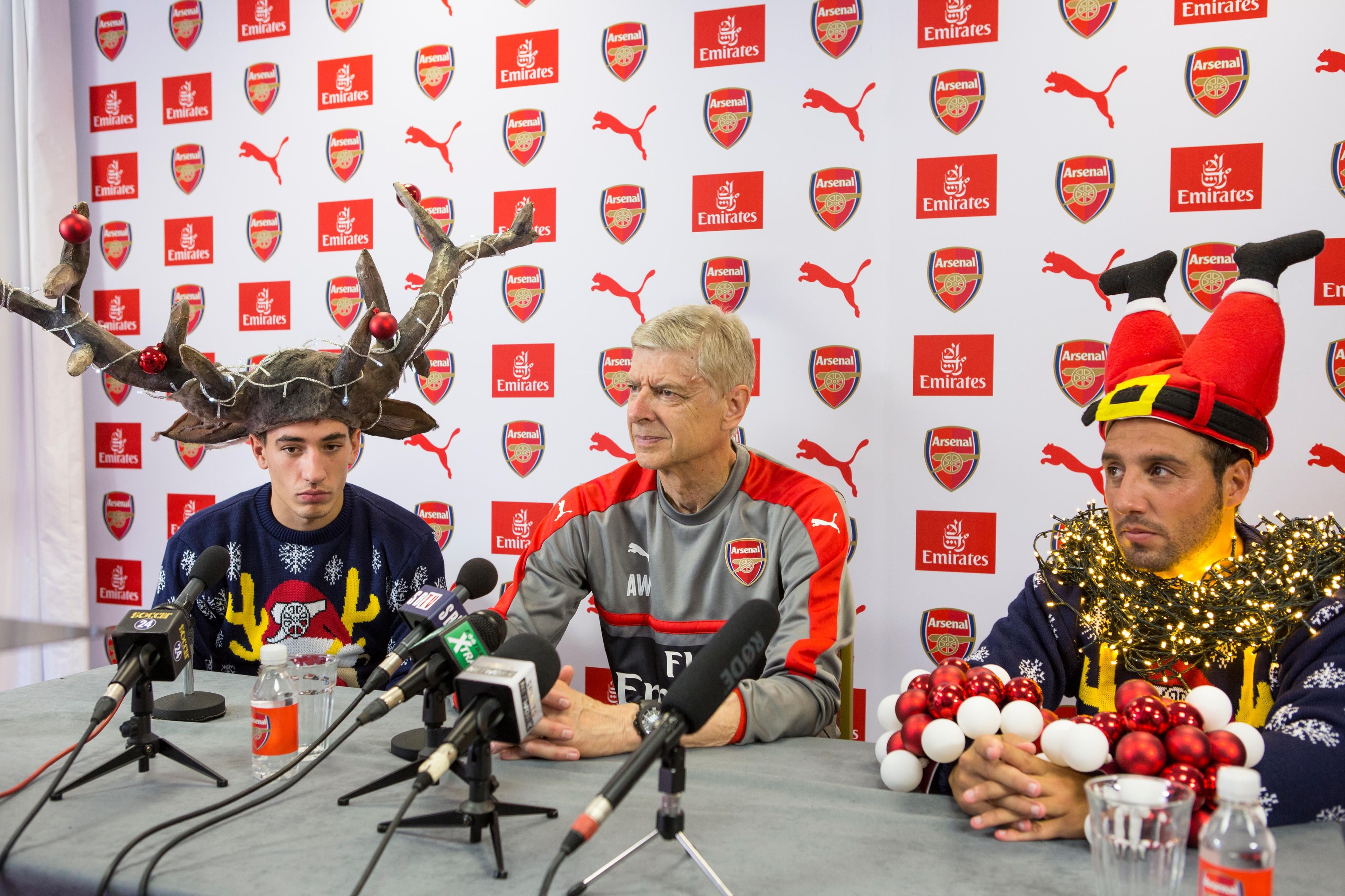 Der FC Arsenal um Teammanager Arsène Wenger (M.), Hector Bellerin (l.) und Santi Cazorla unterstützen mithilfe der Erlöse aus dem Weihnachtspullover-Verkauf die Charity-Organisation „Save the Children“.