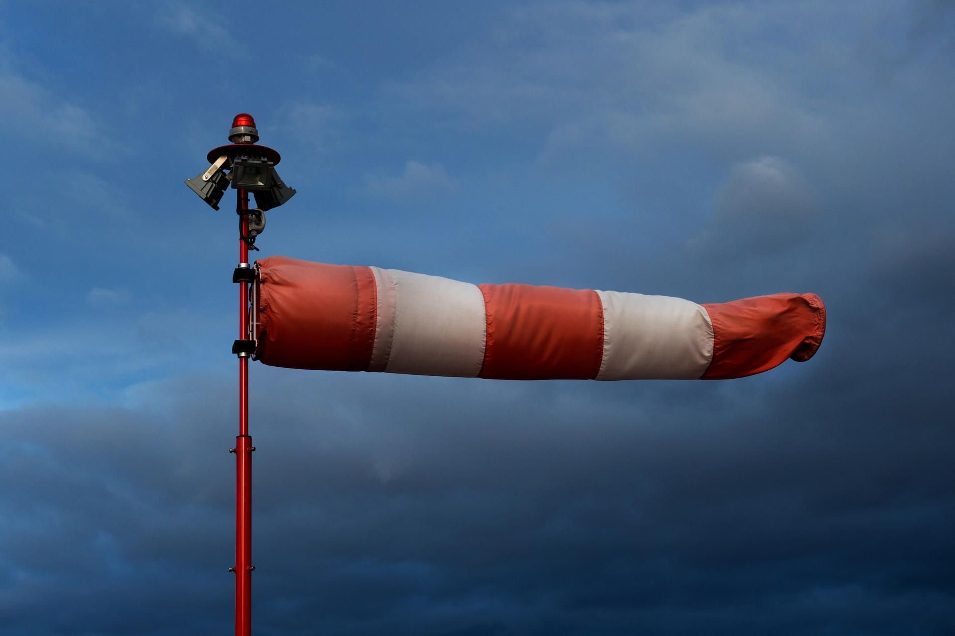 Ein vollends aufgeblähter Windsack weht straff an einem Hubschrauberlandeplatz