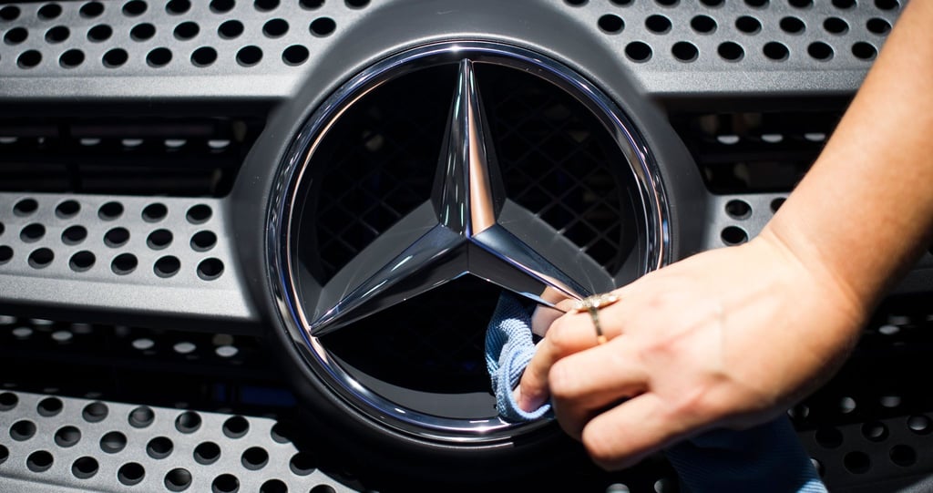 Eine Frau putzt einen Mercedes-Stern.