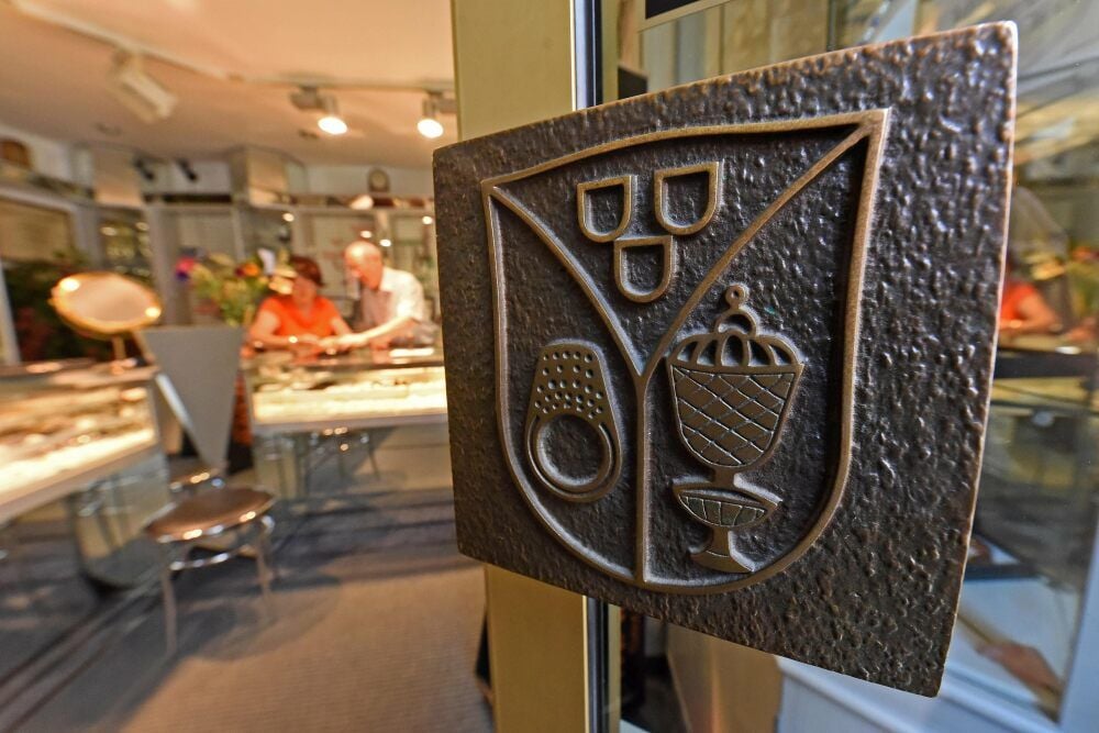 Die Tür zu Geschäft und Werkstatt von Goldschmiede Kunert ziert ein eigenes Wappen als Firmenlogo.