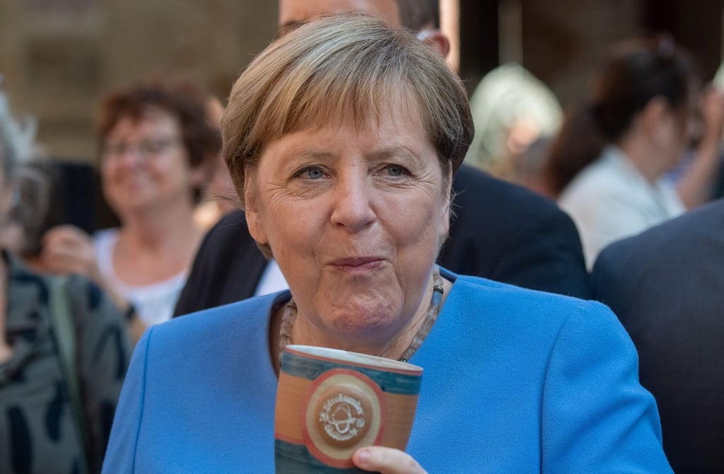 Bundeskanzlerin Angela Merkel (CDU) trinkt bei der Stralsunder Stadtwache ein Bier.