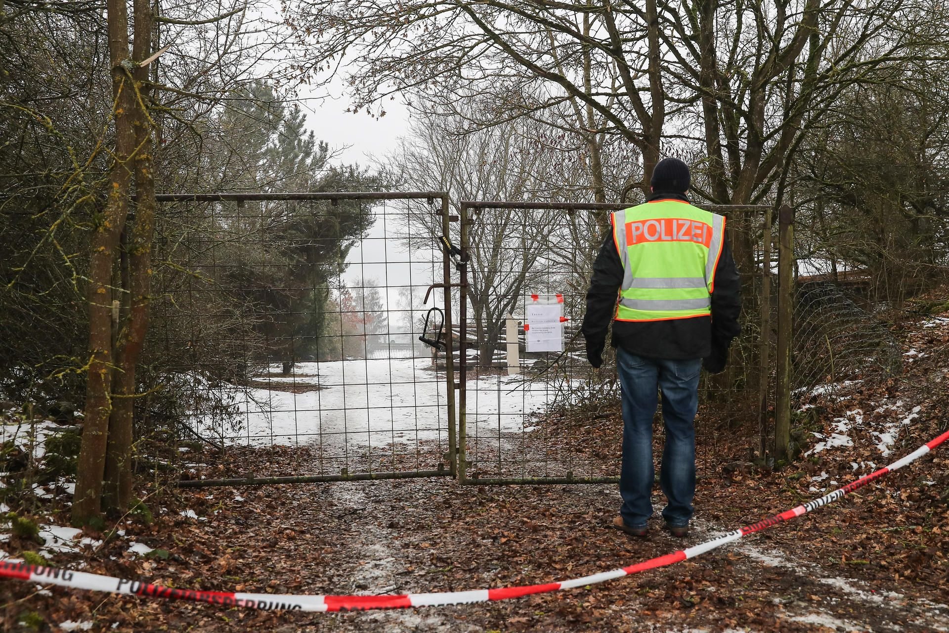 Ein Polizist steht vor der mit Flatterband abgesperrten Zufahrt zu einem privaten Grundstück in der Nähe von Arnstein (Landkreis Main-Spessart) bei Würzburg.