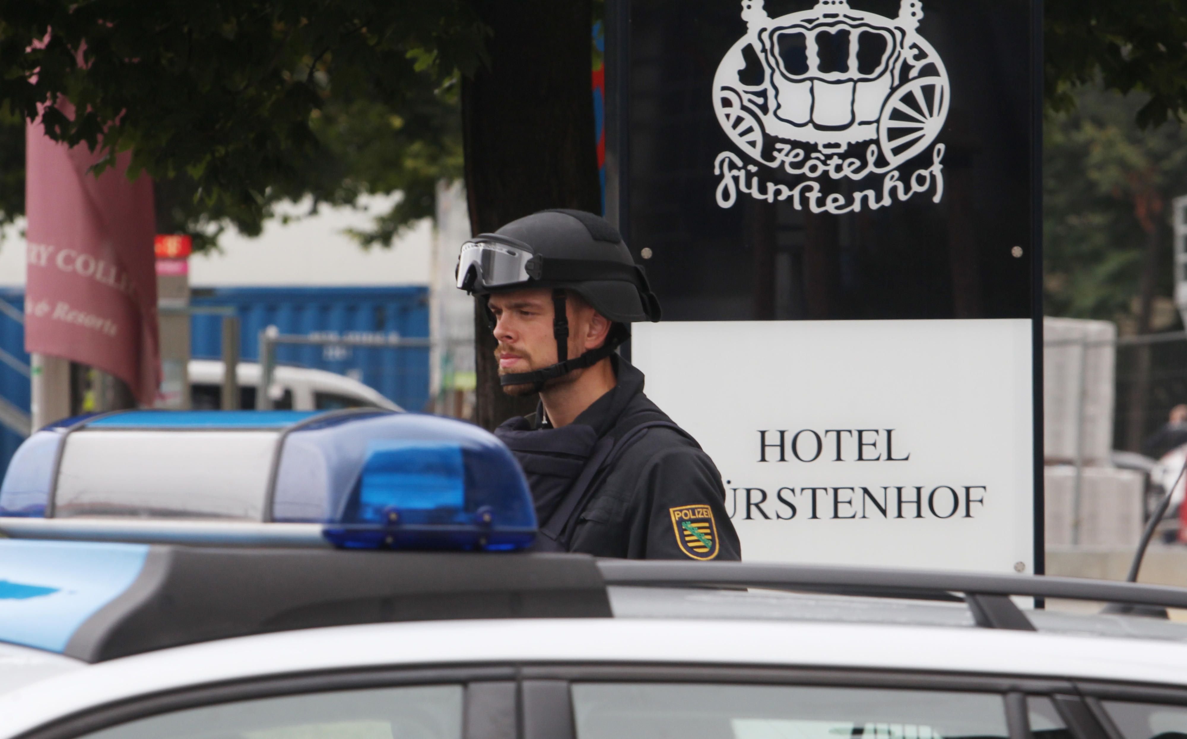 Ein Polizist mit Helm und Schutzweste steht in Leipzig vor dem Hotel Fürstenhof.