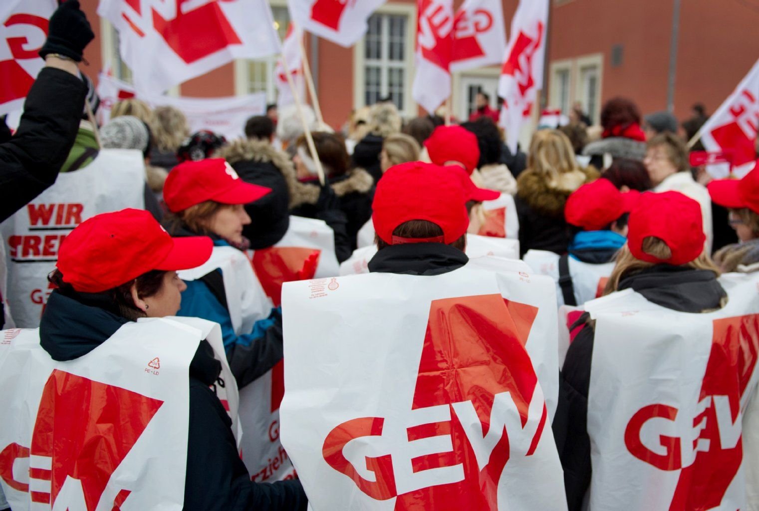 Mitglieder der Gewerkschaft Erziehung und Wissenschaft (GEW) stehen im Februar 2013 in Dessau-Roßlau während einer Kundgebung vor dem Bahnhof.