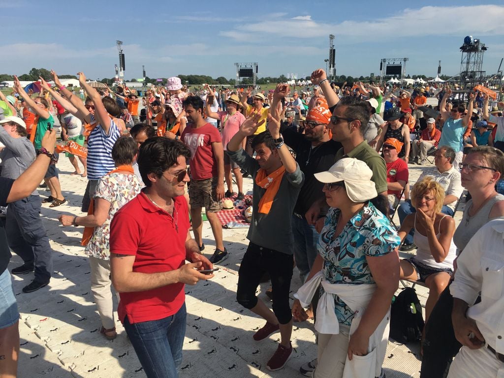 Tanzende Menschen auf der Festwiese des Kirchentages.