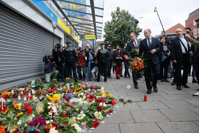 Hamburgs Erster Bürgermeister Olaf Scholz (SPD) und Innensenator Andy Grote (SPD) kommen am 29.07.2017 in Hamburg-Barmbek mit Blumen zu dem Supermarkt, in dem am 28.07.2017 ein Mann einen Menschen mit einem Messer getötet und sechs weitere verletzt hat.