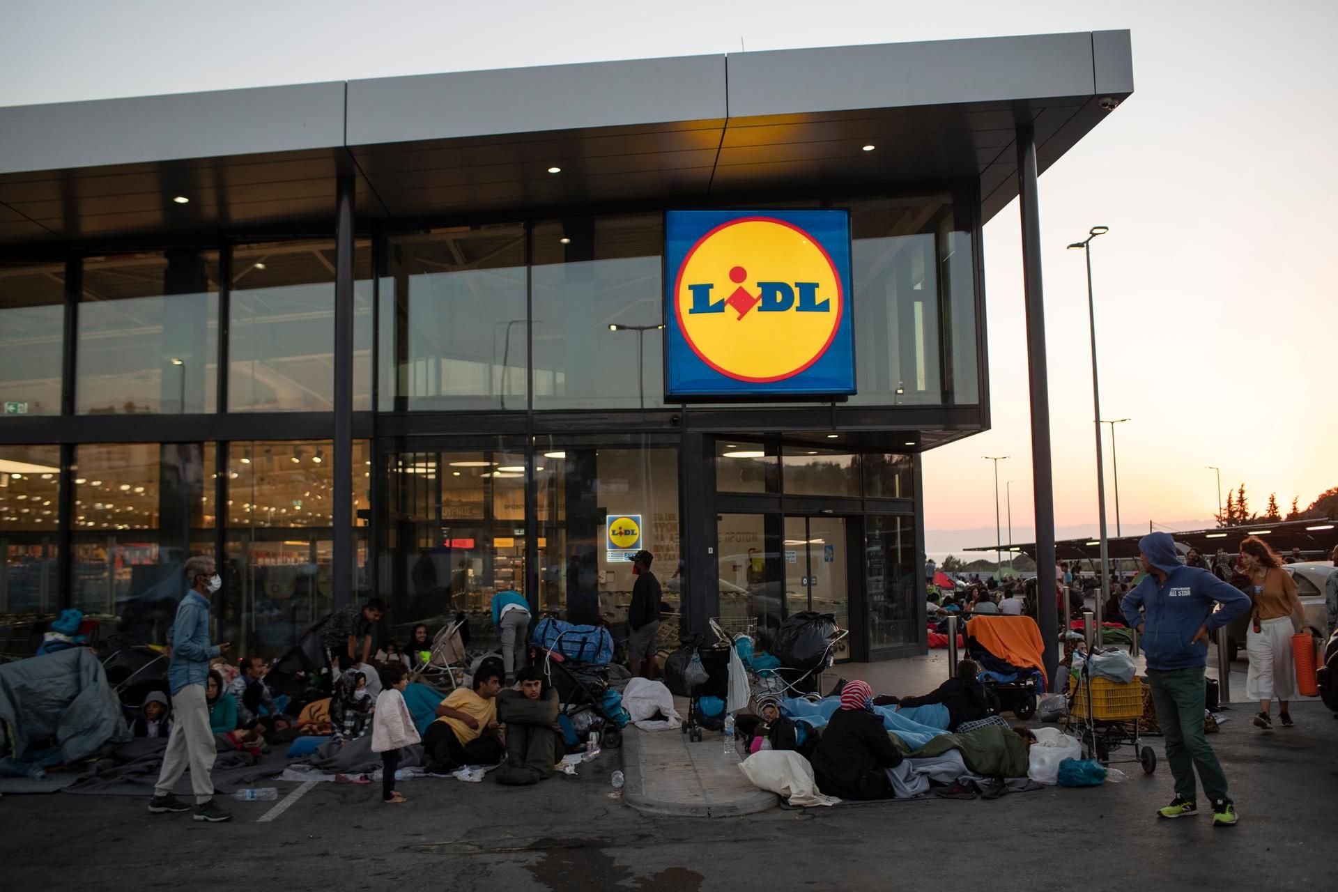 Migranten versammeln sich vor einem Supermarkt auf Lesbos.