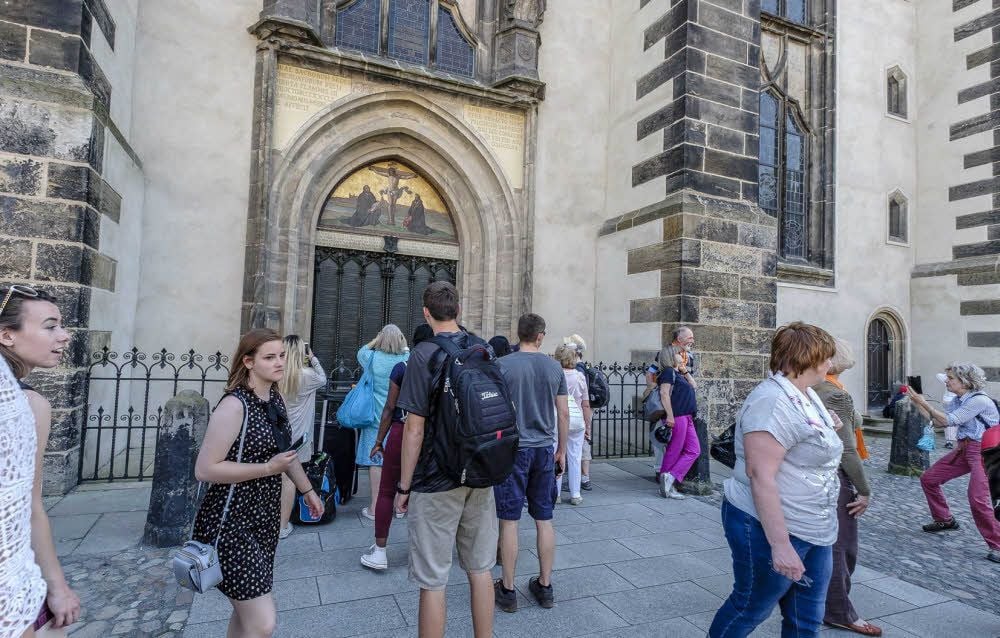 Am Sonntagnachmittag belebt sich nach dem Abschluss des Festgottesdienstes auf der Elbwiese die Wittenberger Altstadt ein bisschen: Besonders die Thesentür ist ein beliebtes Fotomotiv.