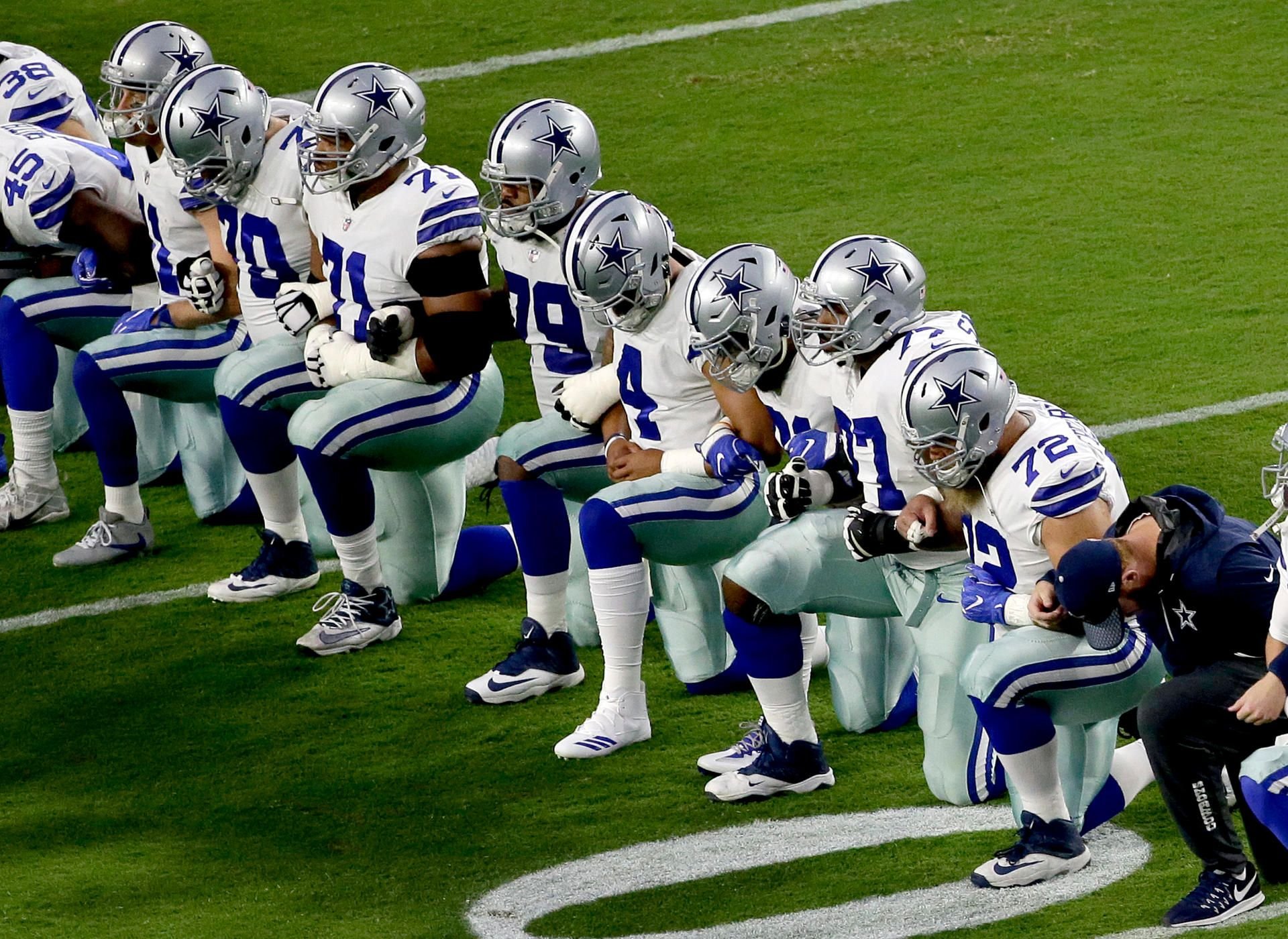 Spieler der Dallas Cowboys knien aus Protest während der Nationalhymne