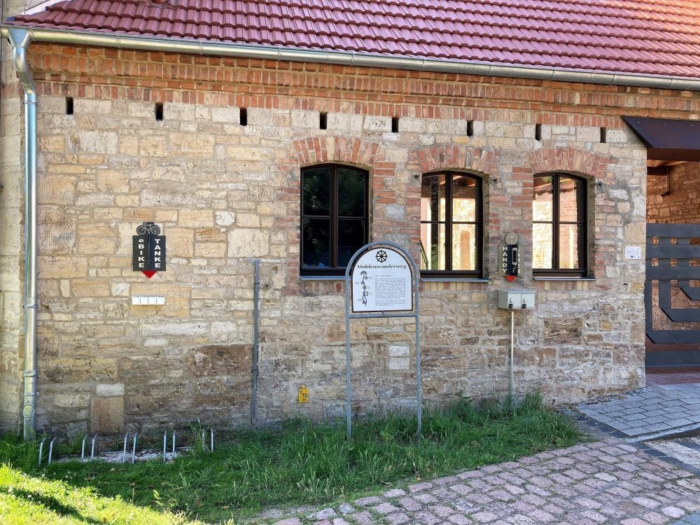 An der sanierten Kreativmühle in Mücheln an der idyllischen Geisel kann man jetzt sein Handy und sein E-Bike aufladen.