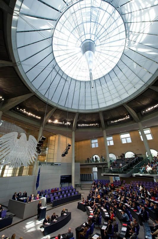 Blick in den Plenarsaal. Am Rednerpult steht die Bundeskanzlerin.