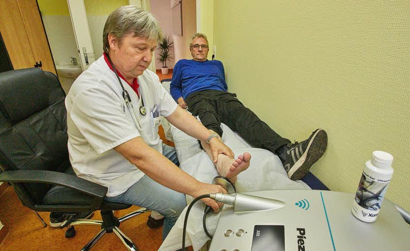 Professor Gerd Meißner therapiert seinen Patienten Andreas Becker mit Schallwellen.