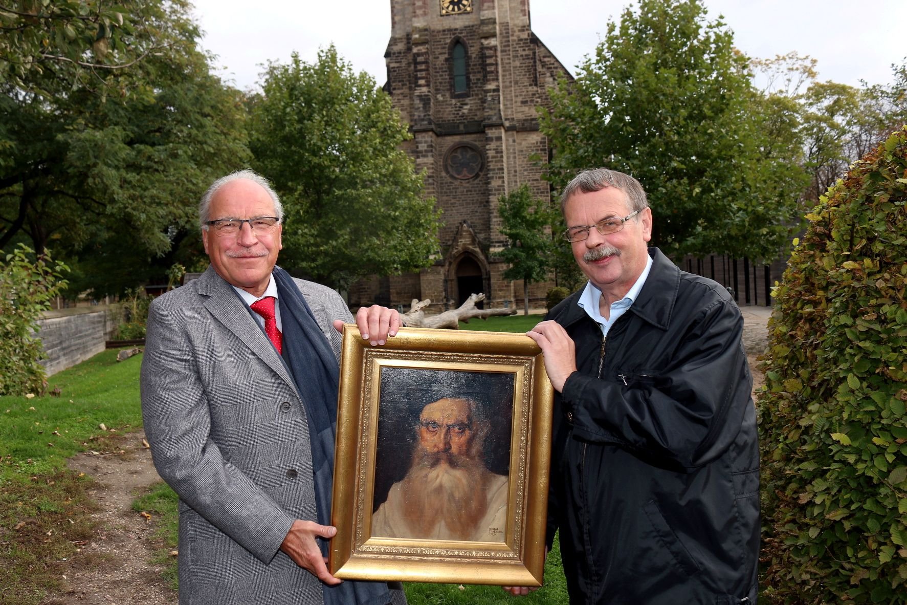 Jürgen Weigelt (l.) übergibt Pfarrer Karl-Heinz Schmidt das Bild.
