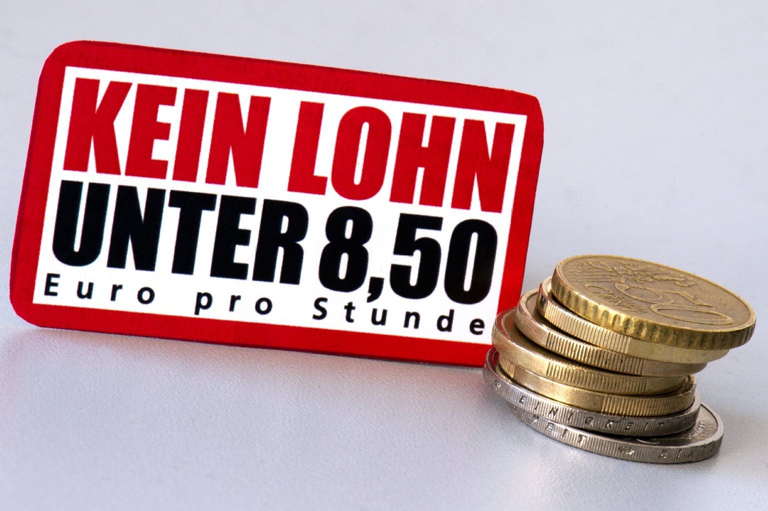 8,50 Euro in Münzen liegenneben dem Ausschnitt einer Infobroschüre des Deutschen Gewerkschaftsbundes (DGB) mit der Aufschrift «Kein Lohn unter 8,50 Euro pro Stunde».