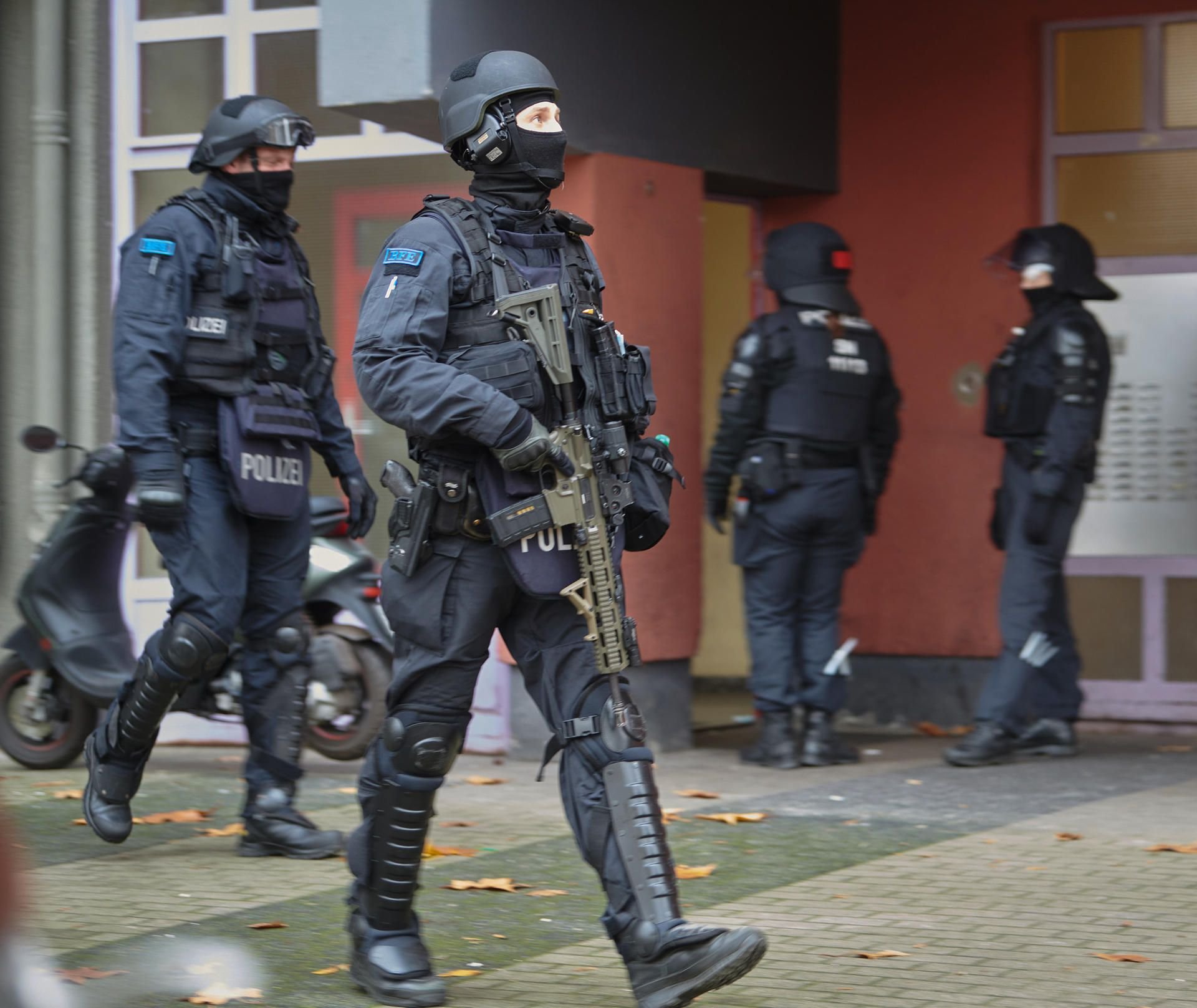 Bewaffnete Polizisten gehen bei einem Einsatz aus einem Hauseingang. Knapp ein Jahr nach dem Kunstdiebstahl im Dresdner Grünen Gewölbe hat die Polizei am Dienstagmorgen in Berlin drei Tatverdächtige festgenommen.