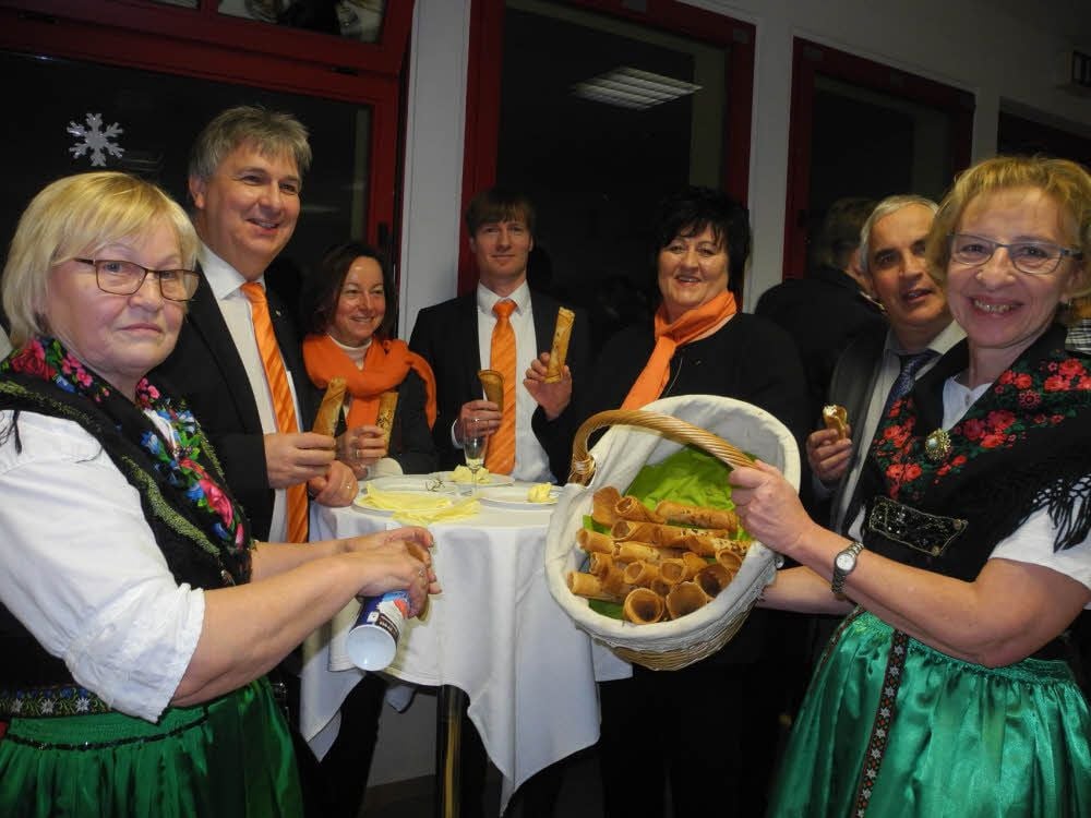 Auch das Team der Jessener Volksbank Elsterland eG und Peter Hans (2.v.r.), Erster Beigeordneter des Elbe-Elster-Landrates, naschen in Schönewalde von den knusprigen Klemmkuchen, die hier Liese-Lotte Sturm (l.) und Heidrun Reich im Fläminger Trachtengewand reichen.