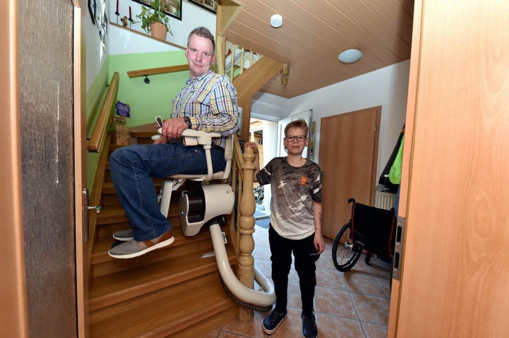 Ronny Müller fährt mit dem neuen Lift die Treppe in seinem Wohnhaus hinauf. Sein elfjähriger Sohn Lenny freut sich, dass der Weg für seinen Vater nun viel einfacher geworden ist.