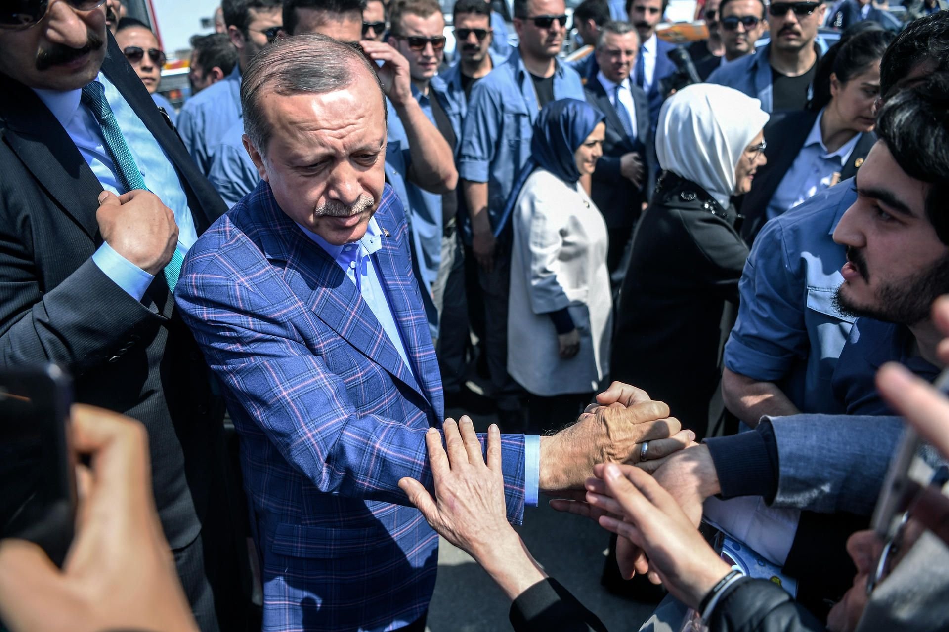 Erdogan verlässt die Wahlkabine und wird von Anhängern bejubelt.