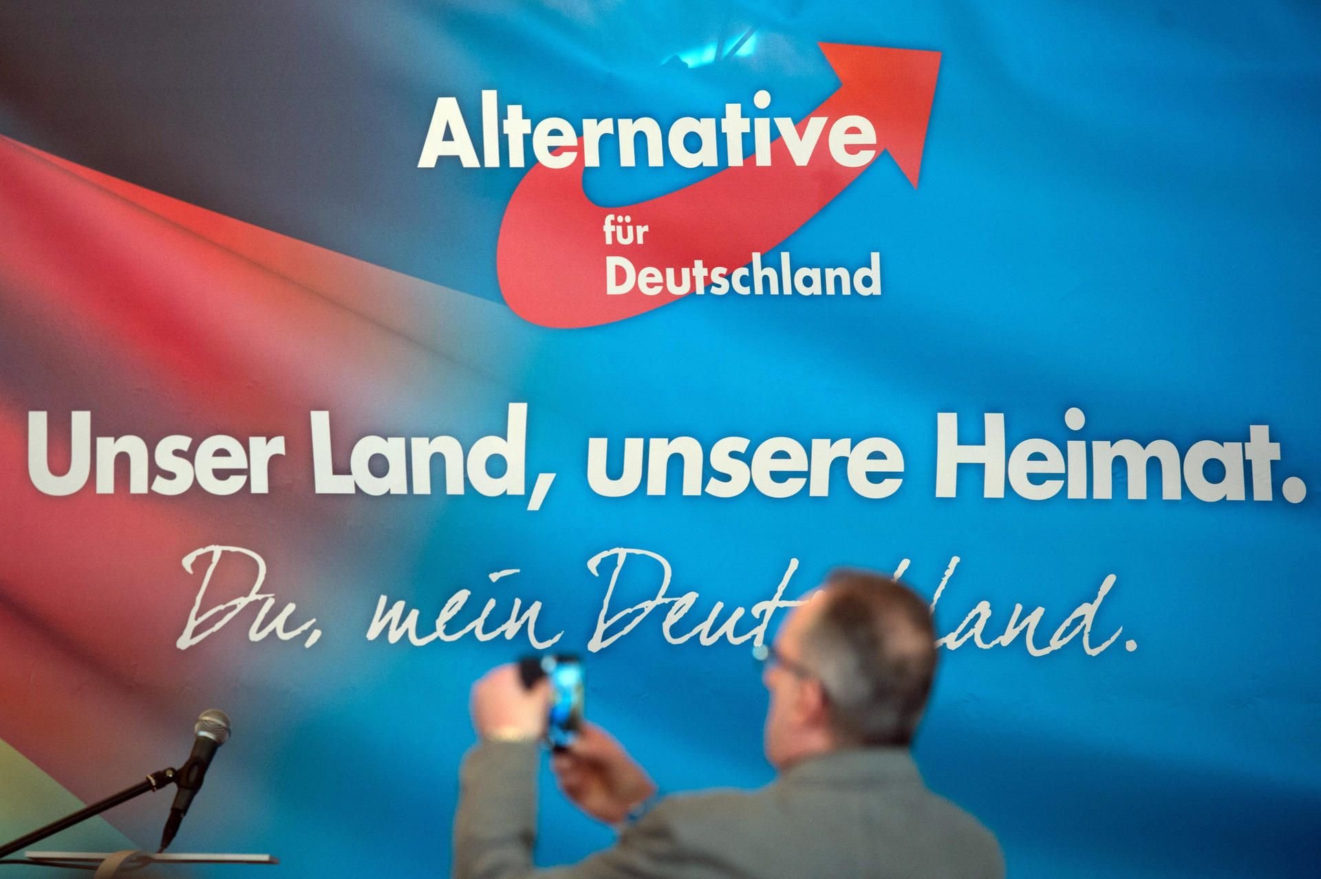 Ein Mann fotografiert am 28. Januar 2017 auf dem Landesparteitag der Alternative für Deutschland (AfD) in Klipphausen (Sachsen) vor einem Transparent mit dem AfD-Parteilogo./Archiv